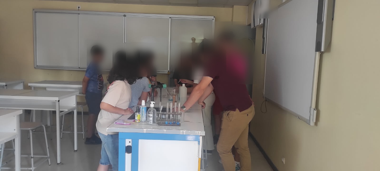 Élèves et professeur réalisant une expérience de sciences au Collège Chambertin